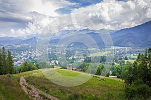 View of the cloudy mountains. In the valley the city of Zakopane