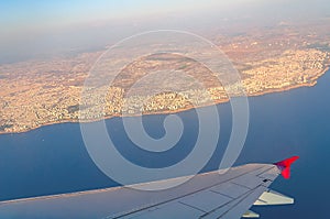 View of the coast of Antalya from the wing of an airplane on a summer day