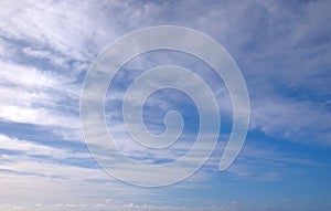 View from the coast of the Easter Island, of blue sky covered by white clouds, over the Pacific Ocean.