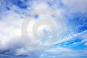 View from the coast of the Easter Island, of blue sky covered by white clouds, over the Pacific Ocean.