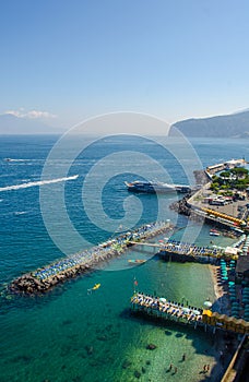 view of coast of italian city sorrento where people may relay on a wooden quay offseting sandy beach....IMAGE