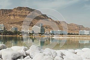 View of the coast and spa hotels at Dead Sea, Ein Bokek, Israel. Salt formations in the foreground. Travel Israel. large salt