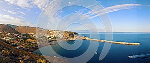 View with coastal buildings, blue water and pier of San Sebastian de la Gomera, Canary Islands