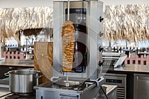 View of a coastal outdoor restaurant equipped with a vertical meat roasting stand.