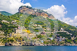 View of coastline Amalfi, beach, sea and mountains with colorful houses on slopes of small town of Amalfi Coast with Gulf of Saler