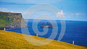 View of coastline cliffs before the ocean on a sunny day in Iceland