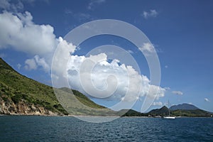 View of the coastline from the sea with a sailing boat, St Kitts, Caribbean
