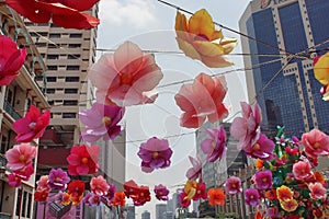 View of colorful decorative artificial flowers hanged above street and road during festival event