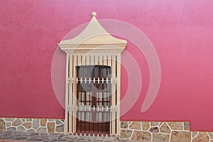 view of colorful house with pink wall and colonial window in pueblo Zimapan Hidalgo Mexico