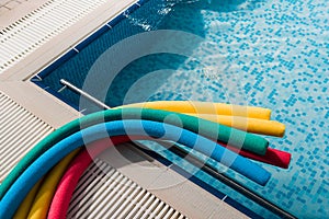 View of colorful pool noodles near swimming pool
