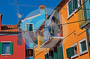 View of colorful terraced houses, balcony and clothes hanging in an alley in Burano.