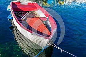 View of a colorful wooden boat moored in the marina in a clear blue sea