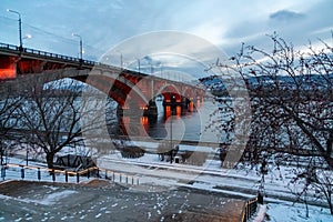 View of the Communal Bridge 1961 with night illumination across the Yenisei River from the embankment of the right bank in the