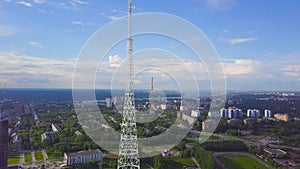 View of communication towers with blue sky, mountain and cityscape background. Video. Top view of the radio tower in the