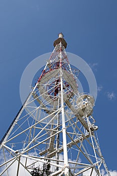 View of communication towers with blue sky. Top view of the radio tower in the city