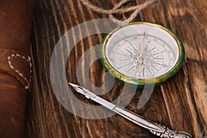 View of compass near nib on brown wooden surface