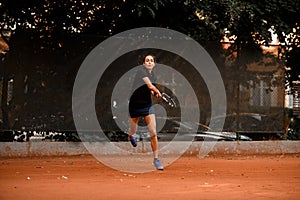 view on confident female tennis player with racket ready to hit a tennis ball.