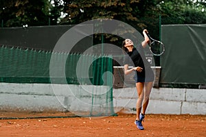 view on confident woman tennis player with racket ready to hit a tennis ball.