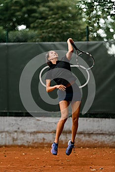 view on confident energy female tennis player with racket ready to hit a tennis ball.