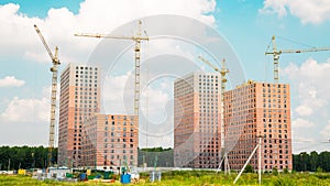 View of the construction of new high-rise buildings with tower cranes on a clear sunny day, construction business