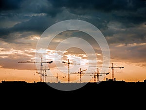 View on a consturction site with cranes during sunset