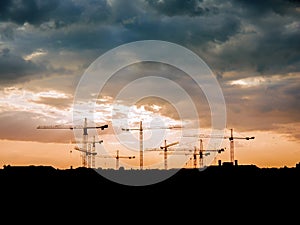 View on a consturction site with cranes during sunset