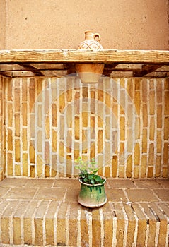 View from the corner of the courtyard of an ancient house that flowers are watered using earthenware. Yazd, Iran