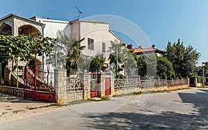View on country two-storey house with gates of coarse stone and