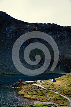 View couple of tourists stand adove the lake. adventures Camping tourism and tent. landscape near water outdoor at Lacul Balea