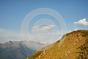 View of a couple watching the sunset on a meadow and the Mountain