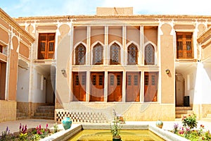 View of the courtyard of an ancient house with a pond and beautiful gardens. Yazd, Iran