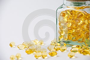 View of covered glass bottle with evening primrose oil pills, on white background with pills, horizontal,