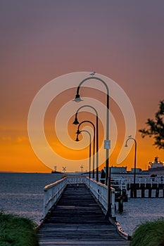 View of cozy pier at vibrant sunset over calm sea