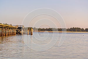 View of the Crab Dock in Winchester Bay, Oregon, with small waves breaking along the sandy beach.