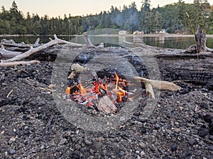 View of a crackling beach camp fire by a lake