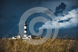 View of Creach Lighthouse in Ushant, France with a cloudy sky in the background