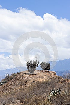View of the cross of Pavas, surrounded by various vegetation and stones on the road, located in Caraz