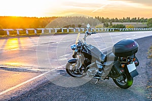 View of a cruise motorcycle on the road against the setting sun