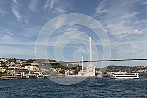 View of cruise tour boats on Bosphorus, historical Ortakoy mosque and bridge in Istanbul. It is a sunny summer day.