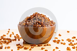 View of crystal caramel, brown sugar cubes in wooden bowl