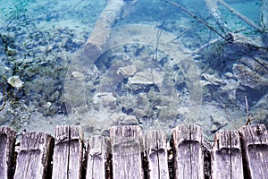 View at crystal clear blue water from wooden boardwalk