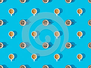 View of cups of fresh coffee on blue, seamless background pattern