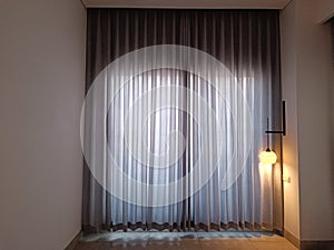 view of the curtains inside the hotel room with a little outside light coming in