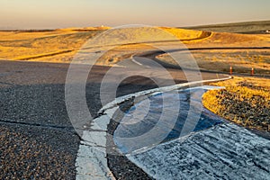 View of a curved dirt road illuminated by the rising sun in Thunderhill Raceway Park, CA