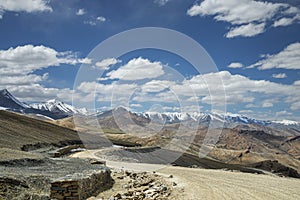 View of curved road among snow capped mountains