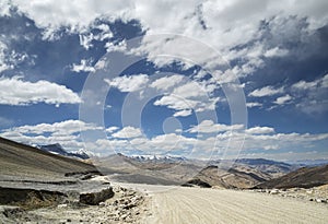 View of curved road among snow capped mountains