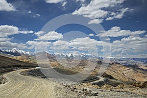 View of curved road among snow capped mountains