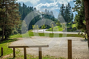 View of curved road surrounded by trees at Hija glamping site at Nova Vas in Slovenia on a sunny day photo