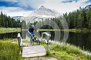 View of cyclist riding mountain bike on trail in Dolomites,Tre C