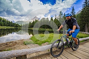 View of cyclist riding mountain bike on trail in Dolomites,Tre C